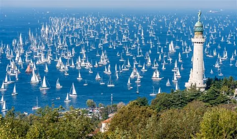 Hundreds of yachts racing in the Barcolana off Trieste, with the Victory Lighthouse in front