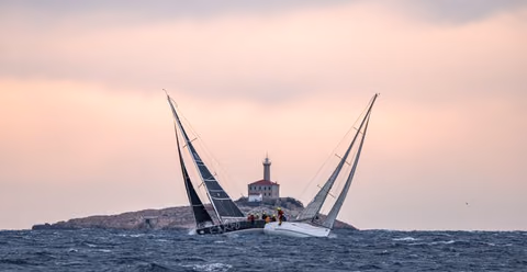 Two yachts heeling in strong wind by a lighthouse during the Regata Jabuka